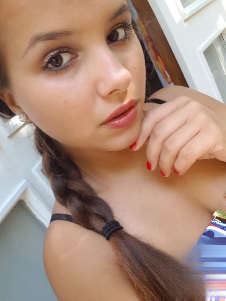 Young looking Latina girl Olivia hides her huge tits while taking selfies