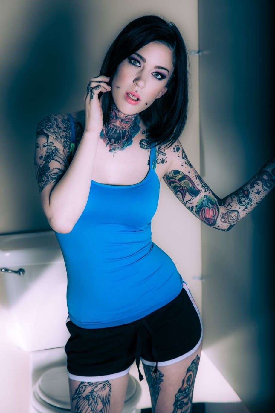 Brunette tattoo model revealing tiny tits and tight ass before masturbating