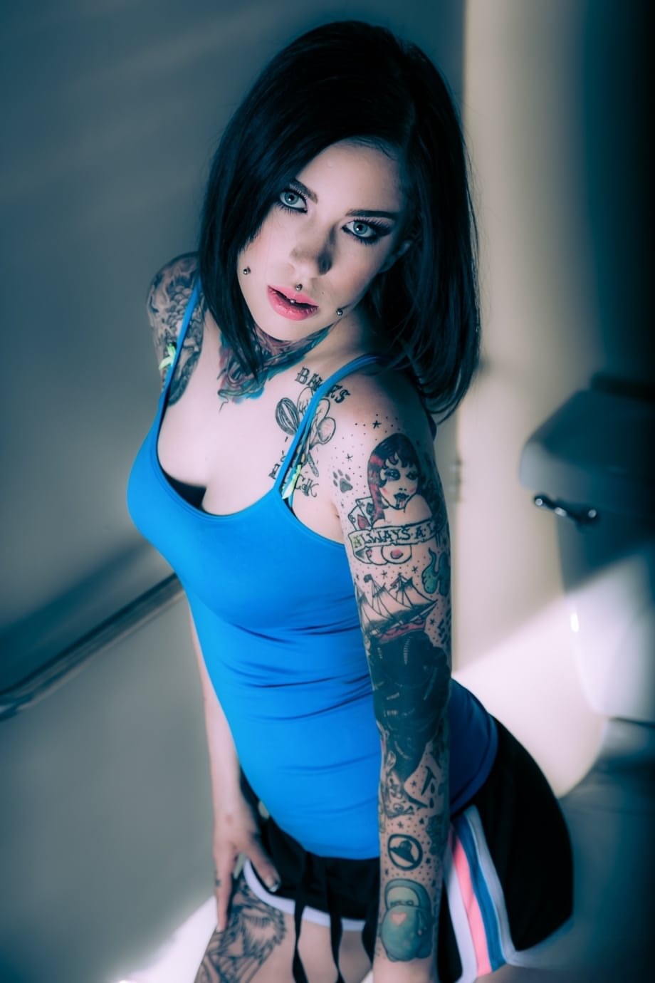 Brunette tattoo model revealing tiny tits and tight ass before masturbating