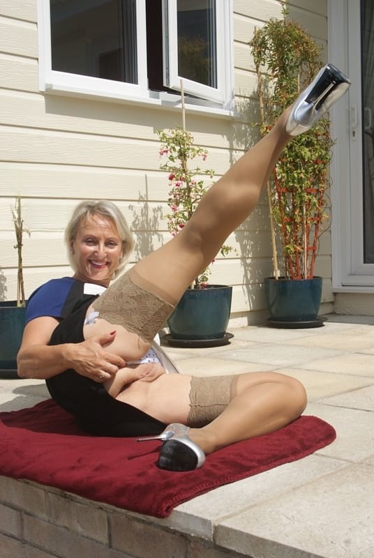 Leggy mature dame in stockings exposing big tits outdoors in high heels