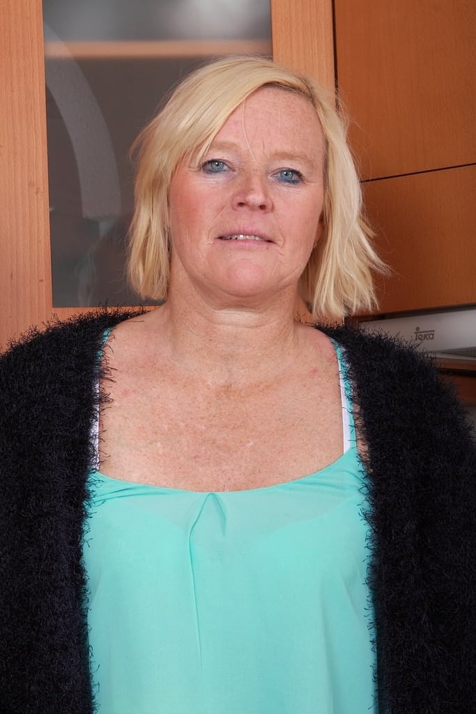 Mature housewife with blonde hair and blue eyes strips naked in her kitchen