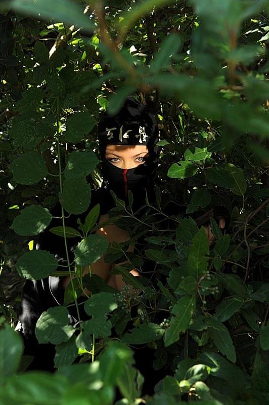 Ninja attired babe Shione Cooper freeing large natural tits in the forest