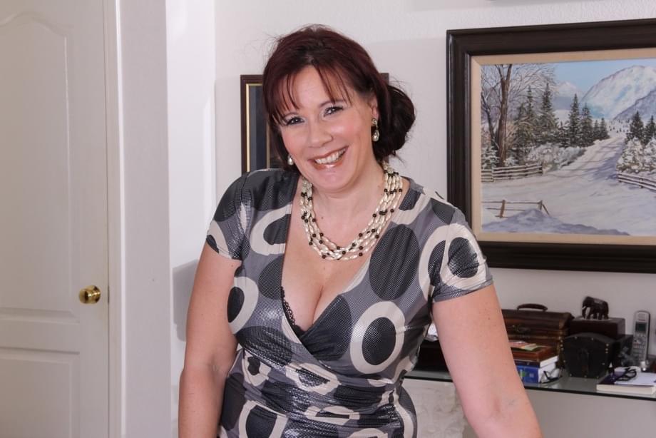 Thick aged woman takes off her dress and black lingerie to pose naked on couch