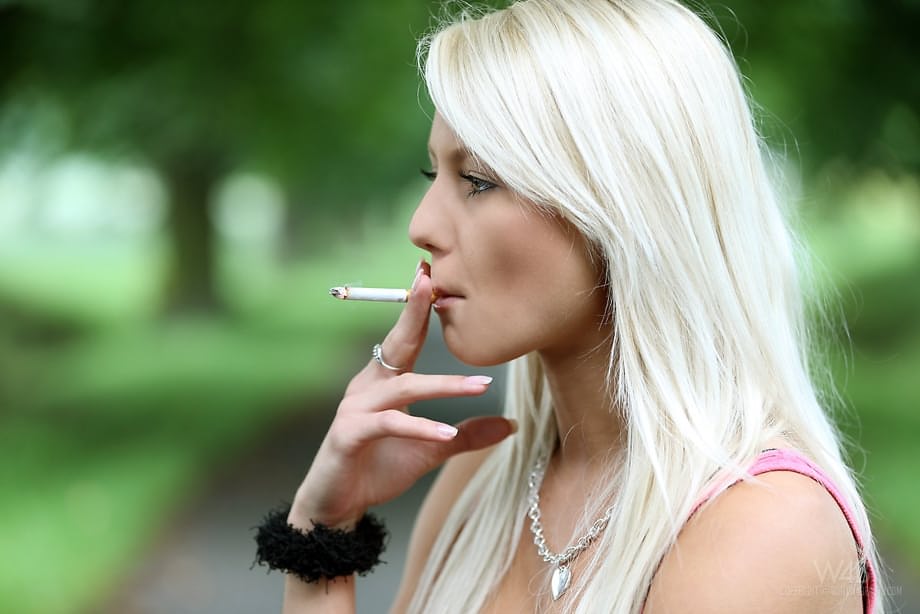 Beautiful blonde teen Grace puts out her smoke and models naked beside road