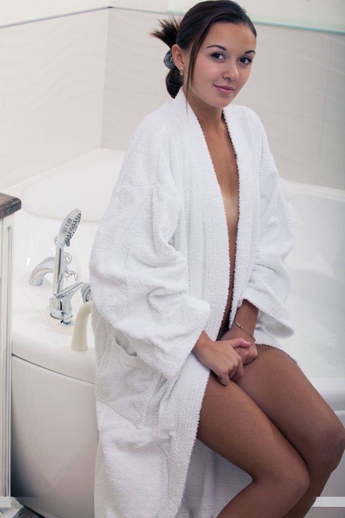 Wet European babe exposing small teen breasts and shaved cunt in bathtub