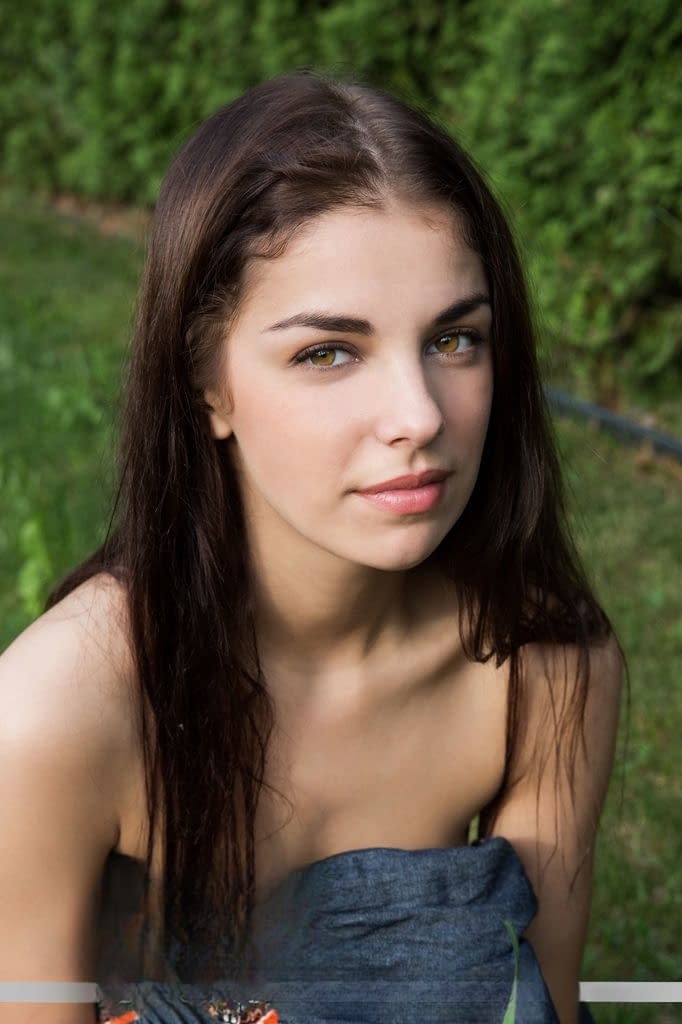 Pretty brunette Evita Lima displaying full teen breasts and cunt outdoors