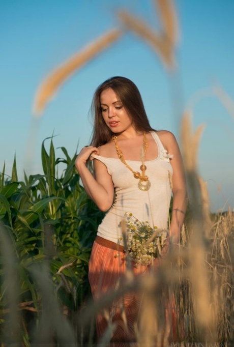Glamour model Arina G stripping naked for nude spread in hay field