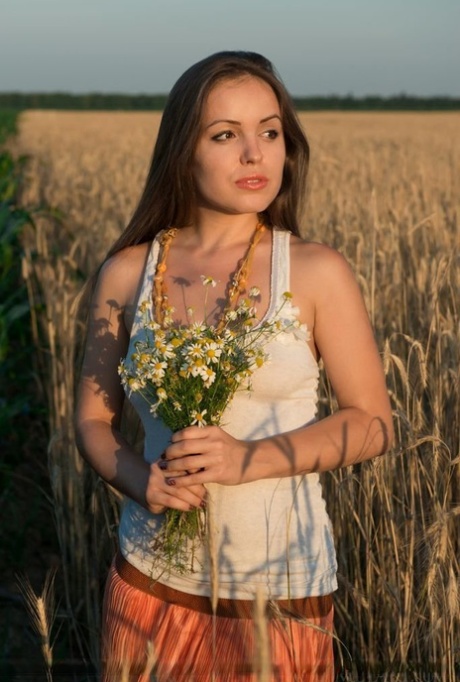 Glamour model Arina G stripping naked for nude spread in hay field