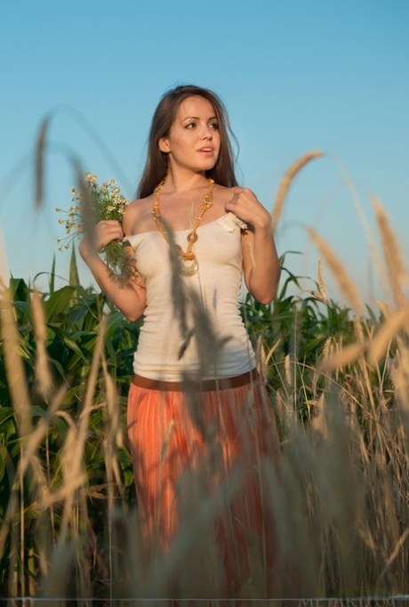 Glamour model Arina G stripping naked for nude spread in hay field