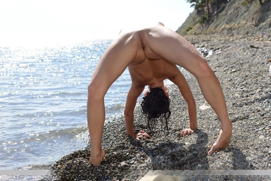 Flexible tiny titted Nensi B on the beach stretching to flaunt bald muff