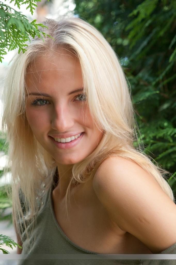 Young blonde female Jaime A stripping off clothes to model naked outdoors