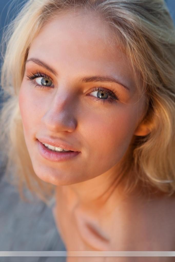 Young blonde female Jaime A stripping off clothes to model naked outdoors