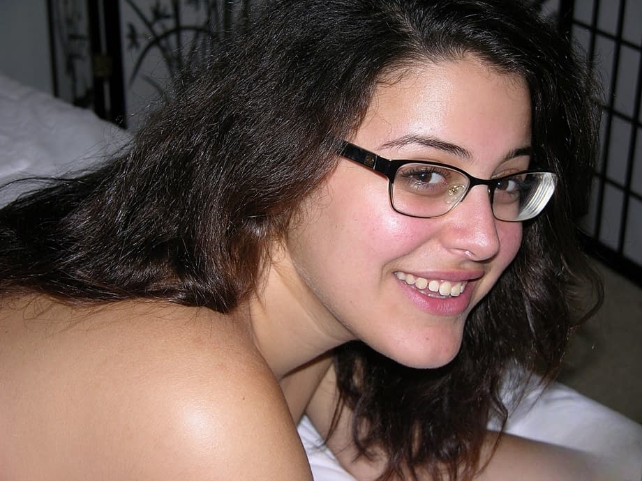 Nerdy girl takes a cumshot on her bare ass after getting naked to jerk a dick