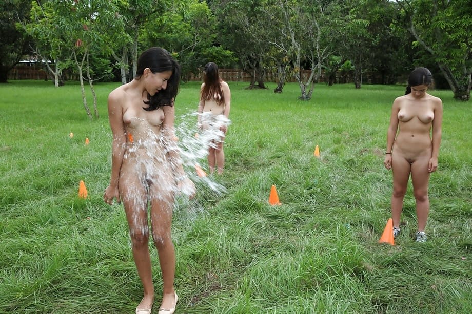 Pretty naked lesbians are standing naked and showing their bodies outdoors