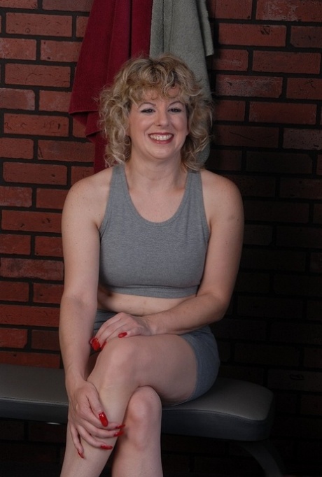 Fit mature woman masturbates inside the fitness center locker room