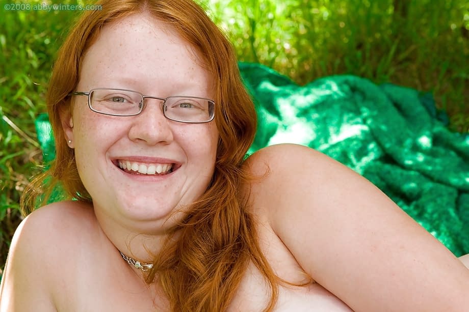 Ugly redhead chick in glasses strips naked outdoors for pussy spreading