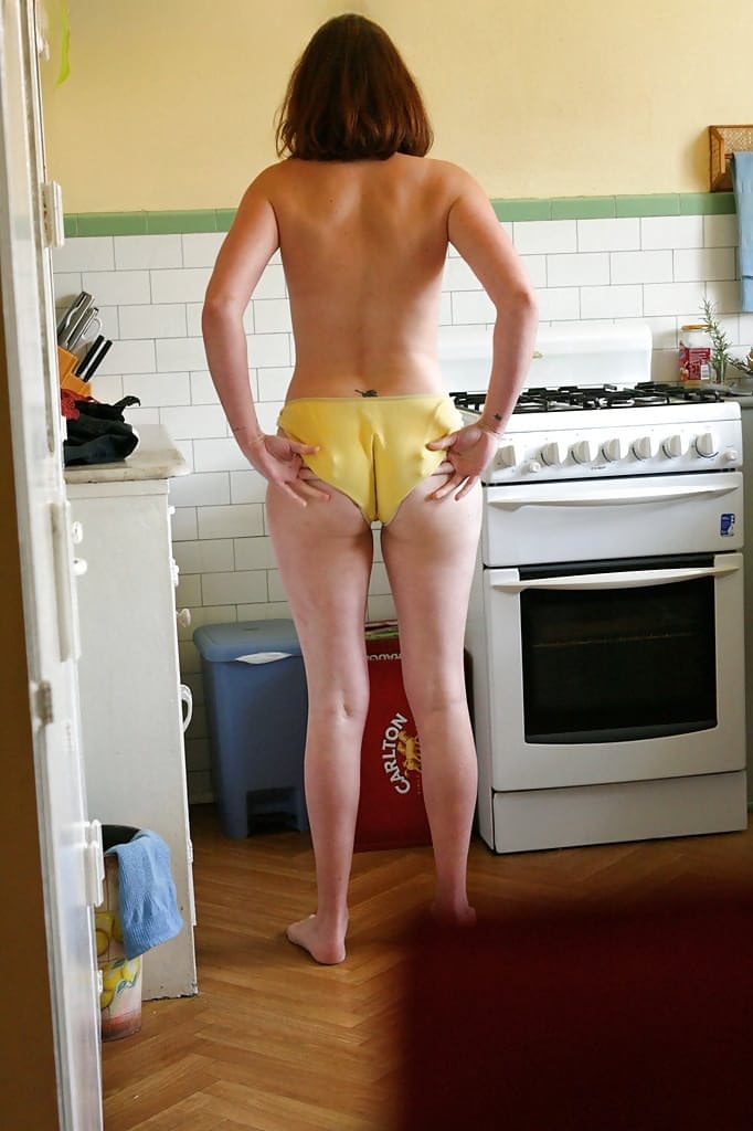 Hidden camera catches nude girl getting dressed in the kitchen