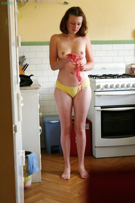 Hidden camera catches nude girl getting dressed in the kitchen