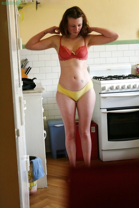 Hidden camera catches nude girl getting dressed in the kitchen