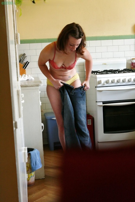 Hidden camera catches nude girl getting dressed in the kitchen