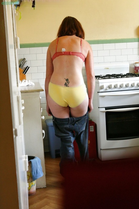 Hidden camera catches nude girl getting dressed in the kitchen