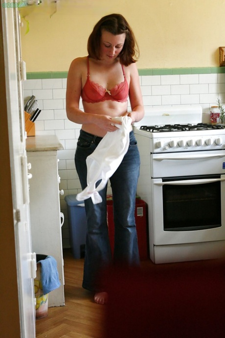 Hidden camera catches nude girl getting dressed in the kitchen