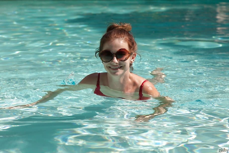Big tit redhead amateur Essie Halladay having fun in a swimming pool