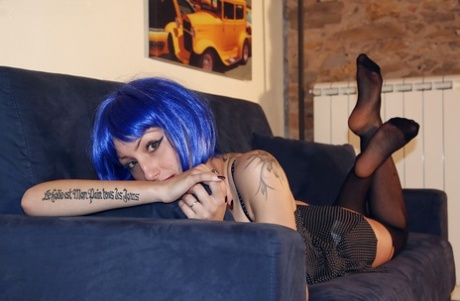 Blue haired alt babe Thena striking sexy poses in black nylons and garters