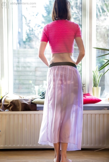 Petite older woman Bonnie C pulling on lace underwear and skirt