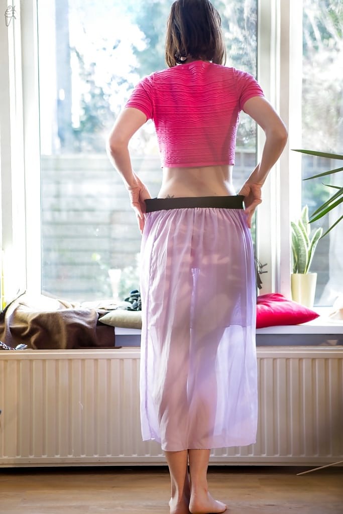 Petite older woman Bonnie C pulling on lace underwear and skirt
