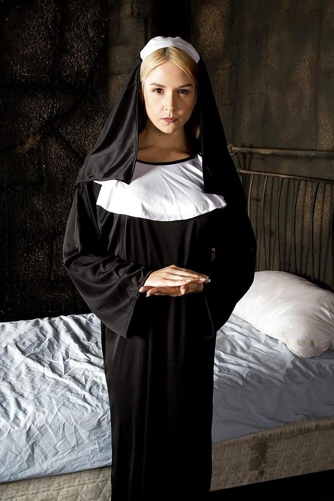 Blonde babe Sara Sloane strips off nun's uniform to expose big tits