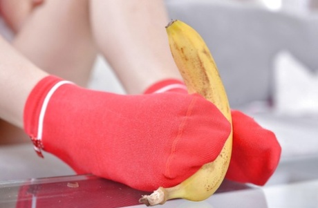 Leggy babe Ariana Brown squashing banana with barefeet after socks removal