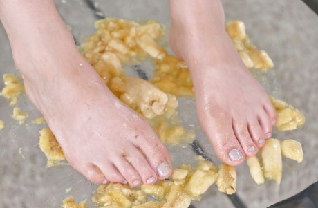Leggy babe Ariana Brown squashing banana with barefeet after socks removal