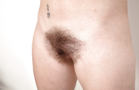 Mature woman in horse riding apparel revealing hairy cunt while undressing