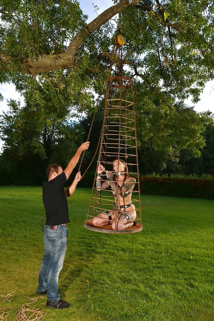 Inked fetish model undergoing outdoors slave training in collar