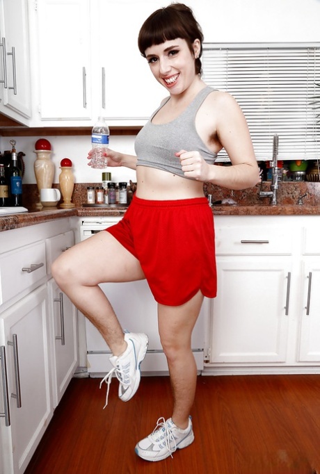 All natural solo model Simone Delilah displaying hairy body parts in kitchen