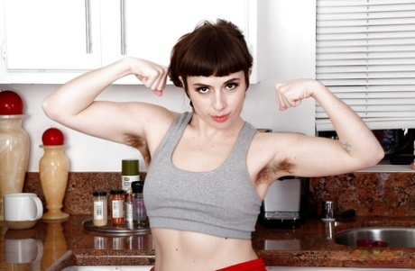 All natural solo model Simone Delilah displaying hairy body parts in kitchen