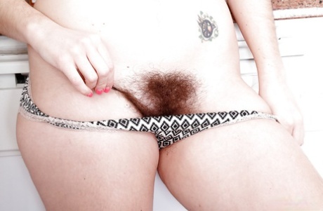 All natural solo model Simone Delilah displaying hairy body parts in kitchen