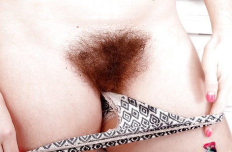 All natural solo model Simone Delilah displaying hairy body parts in kitchen