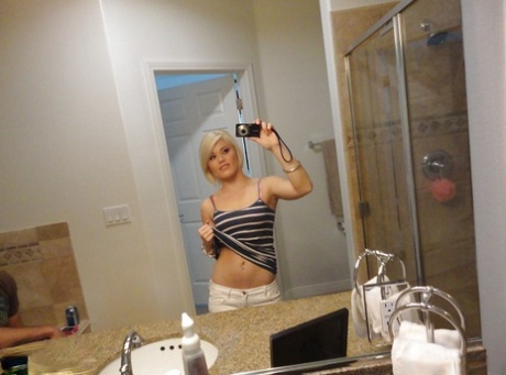 Young blonde hottie Ash Hollywood taking selfies in mirror while undressing