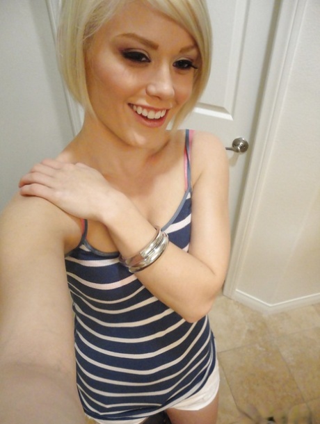 Young blonde hottie Ash Hollywood taking selfies in mirror while undressing