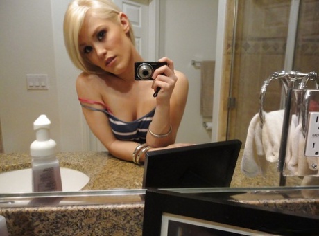 Young blonde hottie Ash Hollywood taking selfies in mirror while undressing