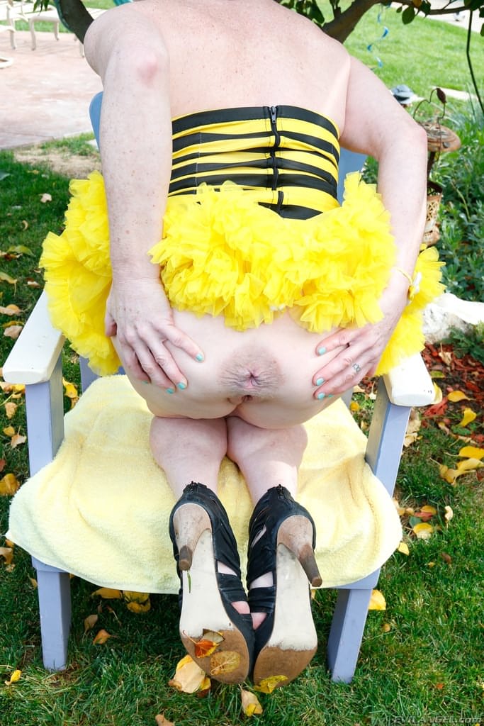 Middle-aged redhead hikes up her bumblebee costume and spreads her cunt lips