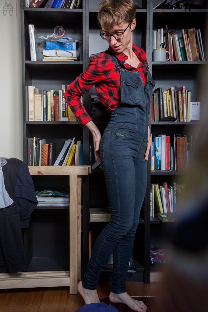 Skinny amateur Gretchen dresses herself among library stacks