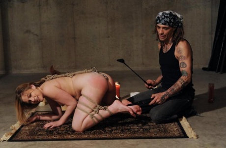 Submissive female is subdued with rope and anal hook before a spanking