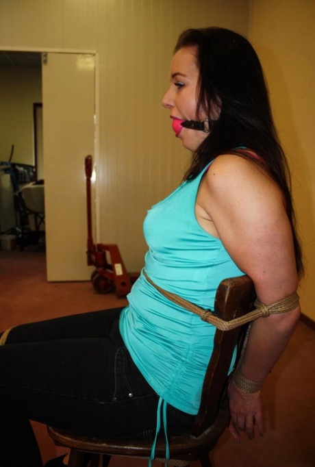 Ball gagged brunette is left all alone tied to a chair with ropes