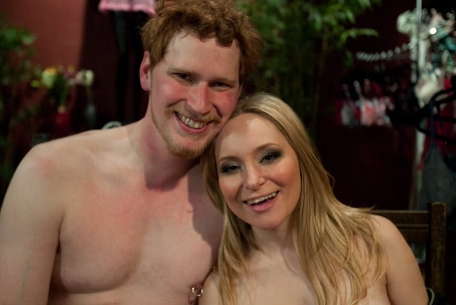 Lusty domme Aiden Starr masturbates while giving a handjob to a tied up guy