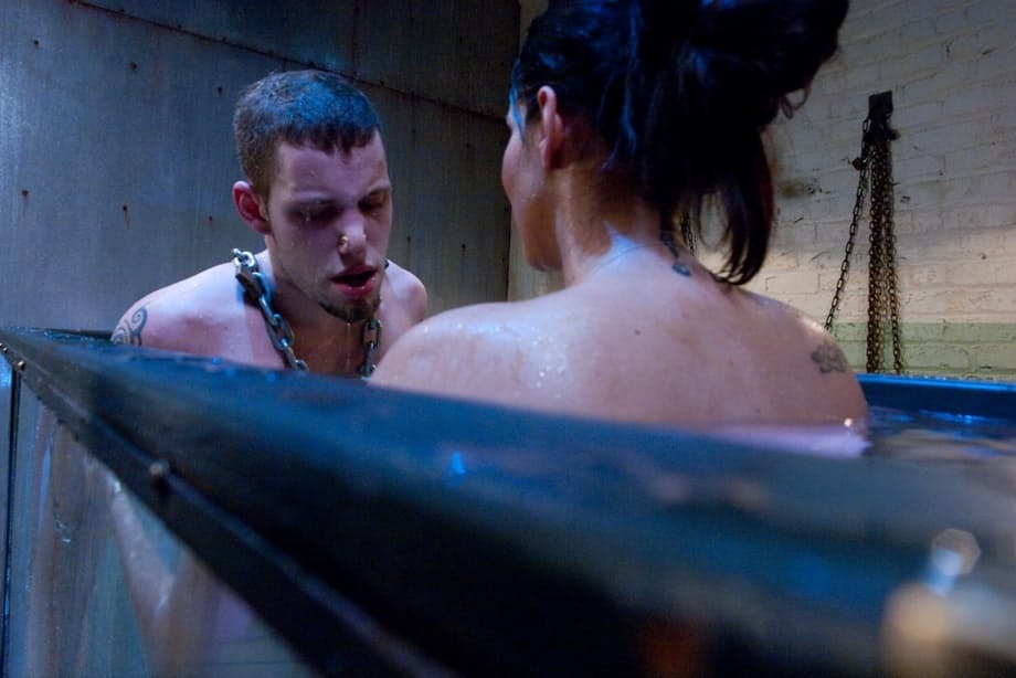 Goddess Isis Love playing with a chained BDSM male sub's cock under the water