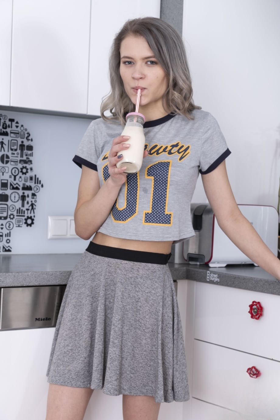 Young Kira J spreads her hairy pussy in the kitchen after a sexy striptease