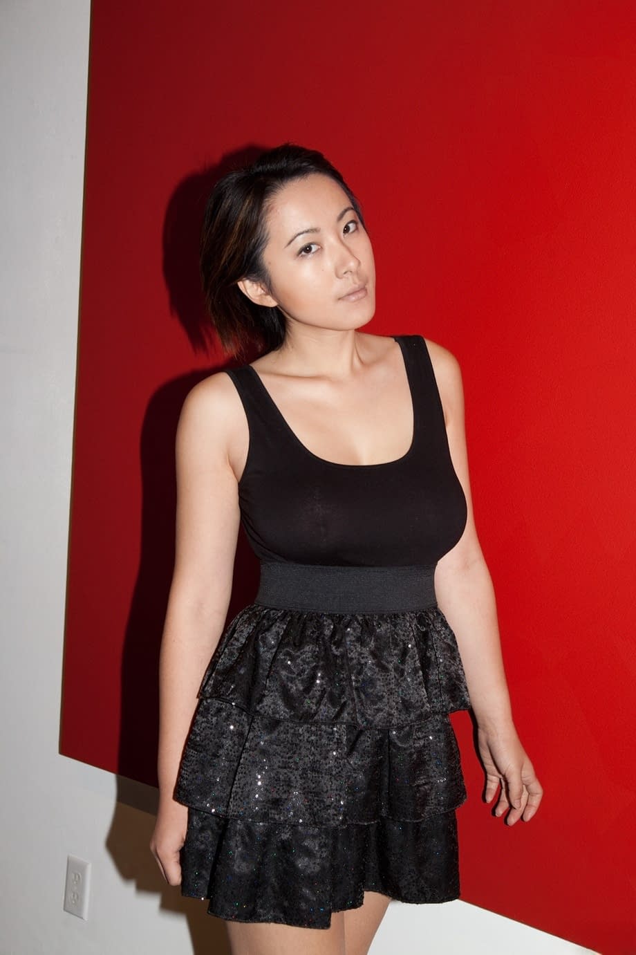 Skinny Chinese babe Li Zheng poses in the black T-shirt and skirt